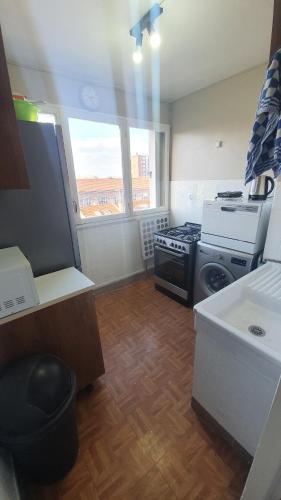 uma pequena cozinha com um fogão e um lavatório em Charmant et Spacieux Appartement em Le Pré-Saint-Gervais