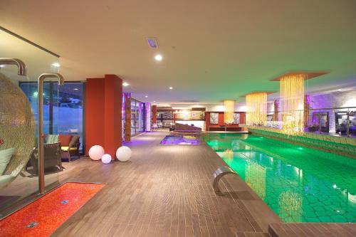 een zwembad in een hotelkamer met een zwembad bij Design Oberosler Hotel in Madonna di Campiglio