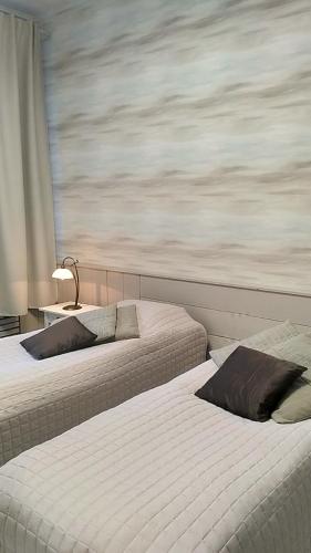 GuestHouse Ikimetsä في كوسامو: سريرين في غرفة مع نافذة كبيرة