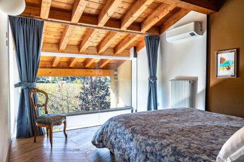 a bedroom with a bed and a large window at Agriturismo Corte Patrizia in Caprino Veronese