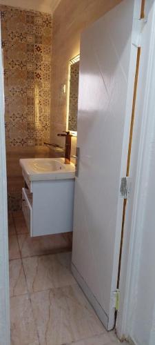 a white bathroom with a sink and a mirror at Nasr city Cozy Studio _ 2 bedrooms in Cairo