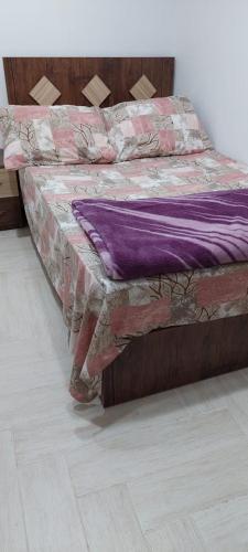 a bed in a room with a purple blanket on it at Nasr city Cozy Studio _ 2 bedrooms in Cairo
