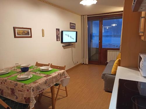 a small living room with a table and a television at Fagus Cervinia apartment Vda Vacanze in Vetta CIR 0206 in Breuil-Cervinia