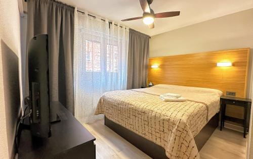 1 dormitorio con 1 cama y ventilador de techo en Apartment Monfort, en Valencia
