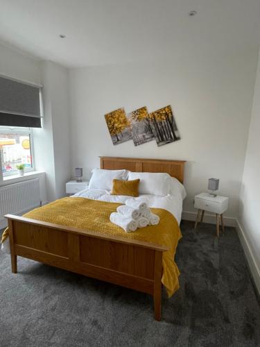 Newly renovated flat in Ashtead في Ashtead: غرفة نوم بسرير كبير مع بطانية صفراء