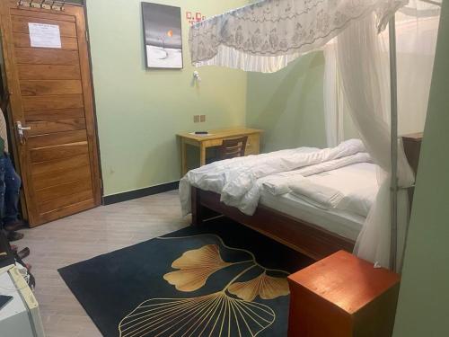 a bedroom with a canopy bed and a rug at The first royal tour lodge in Dodoma