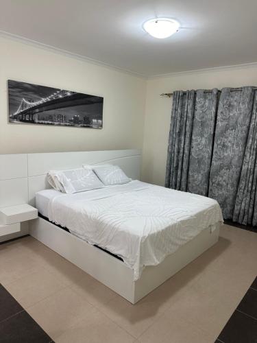 een slaapkamer met een wit bed en een raam bij Furnished 2 Bedroom Apartment in Lavington Nairobi in Nairobi