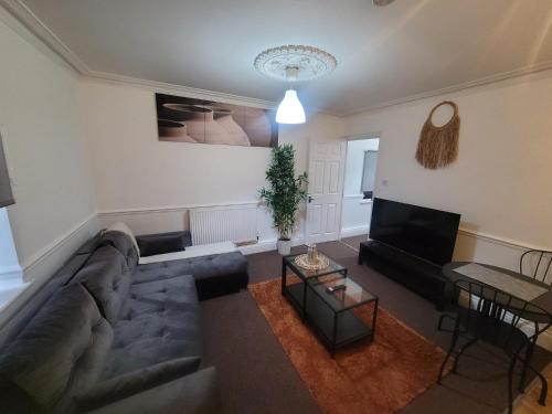 a living room with a couch and a table at Nariken Apartments in Bristol