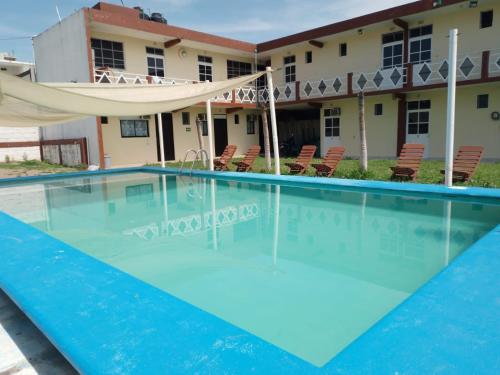 a large swimming pool in front of a building at Hotel María Inés in Veracruz