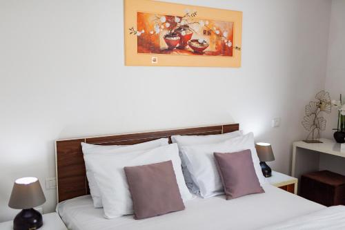 a bedroom with a bed with white and purple pillows at Hotel La mer in Budva