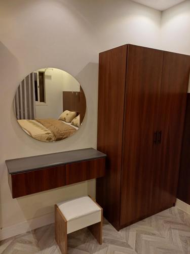 einen Spiegel in der Ecke eines Zimmers mit einem Bett in der Unterkunft شقه فندقيه غرفه وصاله دخول ذاتى in Riad