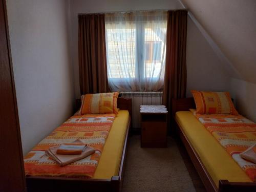 2 camas en una habitación pequeña con ventana en Rent a house - "Laki" en Žabljak