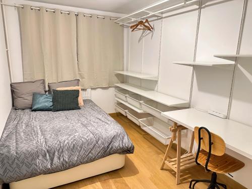 Habitación pequeña con cama y escritorio. en cozy 3 bedroom apartment dans republique en París