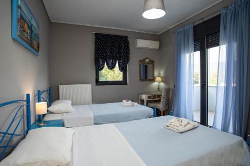 a bedroom with two beds and a window at Villa Aggemari in Apidias Lakos