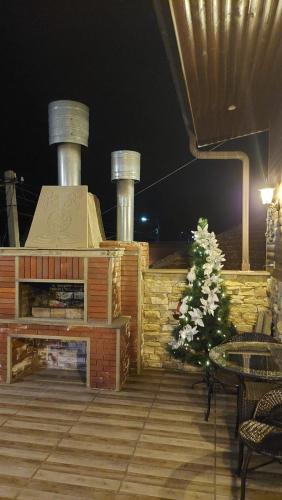 a patio with a fireplace and a christmas tree at Come & Rest in Stepantsminda