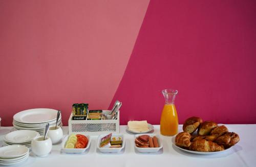 a table with food and bread and a bottle of orange juice at Hotel Monopoli Kutaisi in Kutaisi