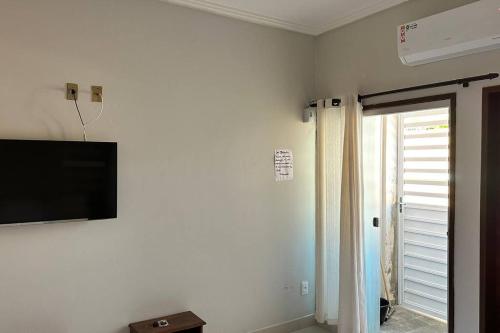 Cette chambre dispose d'une télévision murale à écran plat. dans l'établissement Apartamento frente ao mar na praia do guaibim., à Guaibim