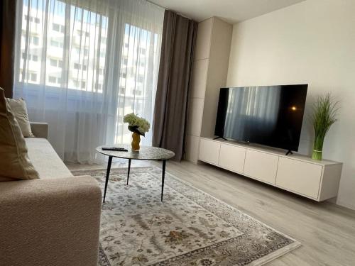 a living room with a tv and a coffee table at SkyNest B404 in Bratislava