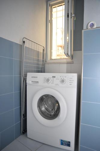 eine Waschmaschine im Bad mit Fenster in der Unterkunft 21 Passi dal Mare in Gaeta