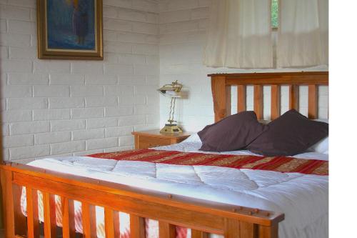 a bedroom with a bed with a wooden frame at Hosteria Cananvalle in Ibarra