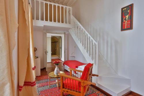 a staircase with a red chair and a vase of flowers at Chems Bleu in Essaouira
