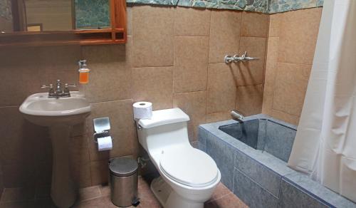 y baño con aseo, lavabo y bañera. en Hosteria Cananvalle, en Ibarra