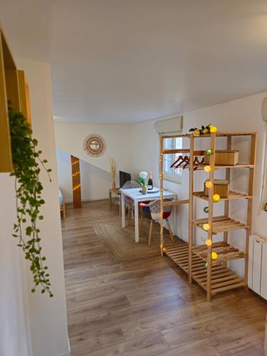 - un salon avec une table et une étagère dans l'établissement Sous les toits de Saint Valery En Caux - situé sur le port de plaisance-, à Saint-Valery-en-Caux