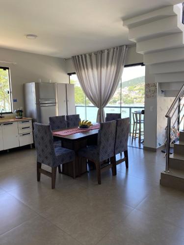 kuchnia ze stołem, krzesłami i lodówką w obiekcie Casa Vista Mar w mieście Governador Celso Ramos