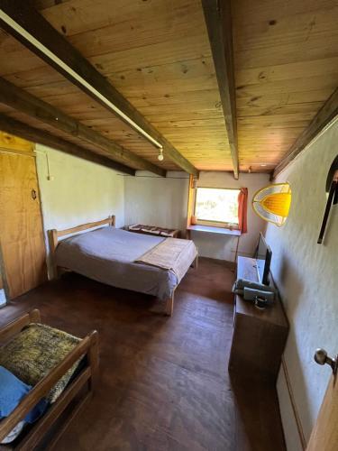 um quarto com uma cama num pequeno quarto em Habitación con baño privado y cama doble em Piriápolis