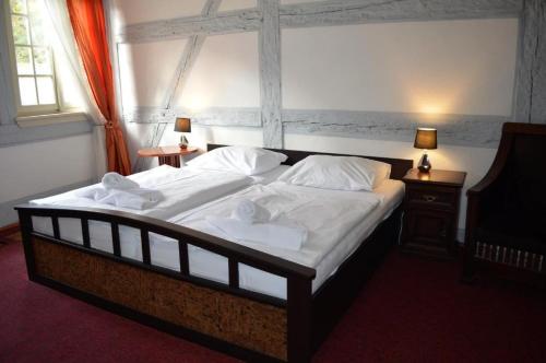 a bedroom with a large bed with white sheets and pillows at Hotel Petr in Karlovy Vary