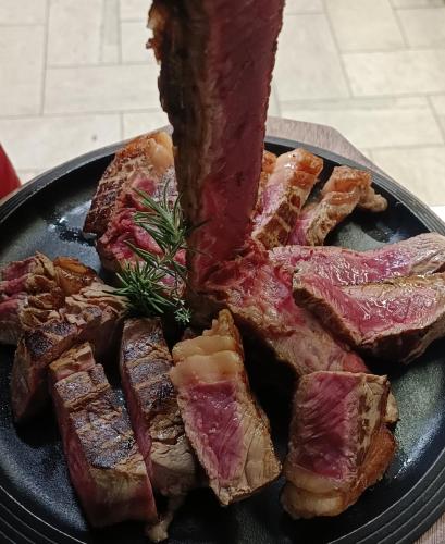 a plate of meat with a piece of bacon at Villa I Barronci Resort & Spa in San Casciano in Val di Pesa