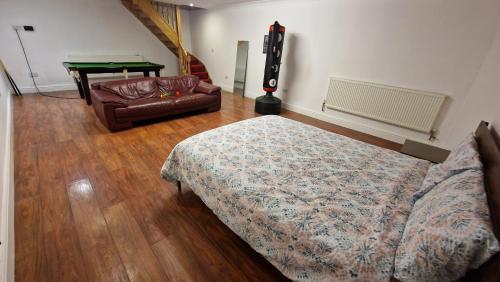 a bedroom with a bed and a couch and a table at Large Annexe Sleep upto 8 in Windsor