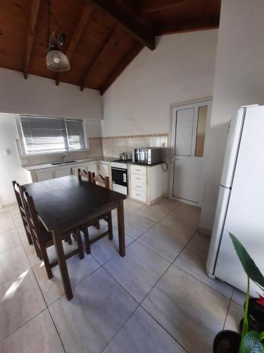eine Küche mit einem Esstisch und einem Kühlschrank in der Unterkunft Necochea-Casa para hasta 4 personas! in Necochea
