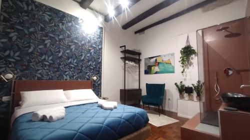Plebiscito Suite Apartment في نابولي: غرفة نوم بسرير ازرق وجدار ازرق