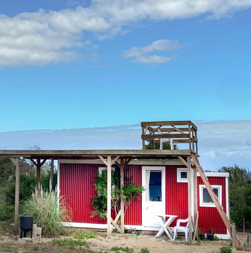 a red and white house with a bed on top at Luna roja in Punta Del Diablo