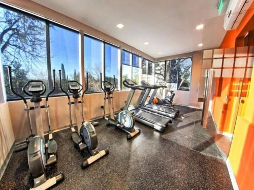 a gym with a row of cardio machines and windows at Guesthouse Luxury in Cordoba