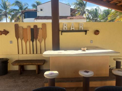 eine Bar mit Holzmessern an einer Wand mit Hockern in der Unterkunft Casa Mana: Beachfront Home w/pool on Playa Blanca in Zihuatanejo