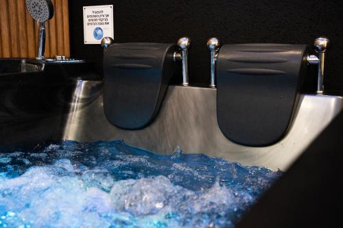 a bathroom with a toilet with blue water in it at צימר אדל - Zimmer Adel in Yavneʼel