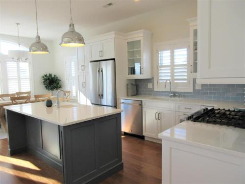 a large kitchen with white cabinets and a refrigerator at Beautiful New Construction 4 Bedroom 35 Bath Home In Holgate in Beach Haven