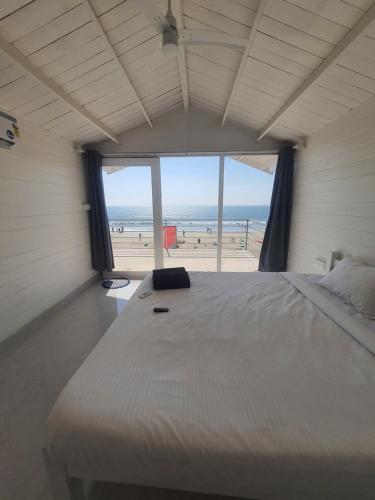 a bedroom with a large bed with a view of the beach at Palolem Beach View Inn in Palolem