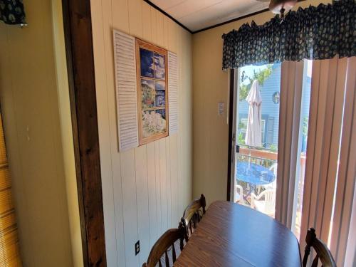 ein Esszimmer mit einem Tisch und einem großen Fenster in der Unterkunft Quaint House Steps To The Beach With Great Backyard Space For Outside Dining in Surf City