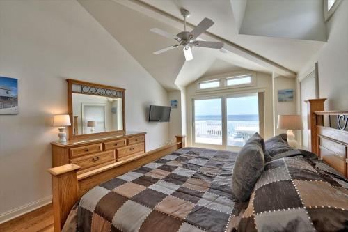 een slaapkamer met een bed, een dressoir en een spiegel bij Spectacular Views Surf City Ocean Front With 6 Bedrooms, Great Beach!! in Surf City
