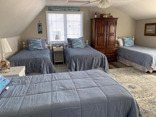 1 dormitorio con 2 camas y ventana en Lovely Cape 5 Homes To The Beach, en Brant Beach