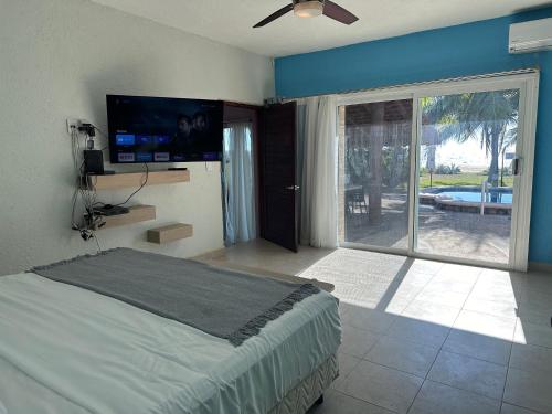 Schlafzimmer mit einem Bett und einer Glasschiebetür in der Unterkunft Casa Mana: Beachfront Home w/pool on Playa Blanca in Zihuatanejo