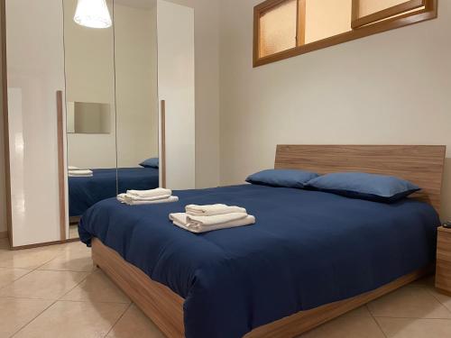 ein Schlafzimmer mit einem blauen Bett und Handtüchern darauf in der Unterkunft da zia Emanuela in Ottaviano