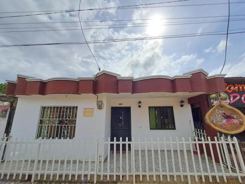 una casa con una recinzione bianca davanti di Casa La Pajarita a Santa Marta