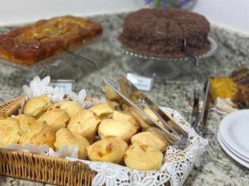 a table with a basket of bread and other pastries at Hotel 7 Quedas in Guaíra