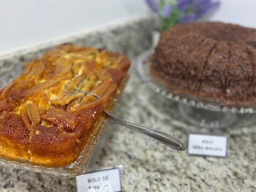 a cake sitting on a counter next to a chocolate cake at Hotel 7 Quedas in Guaíra