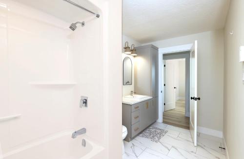 Luxury Homes In Moncton! في مونكتون: حمام أبيض مع حوض ومغسلة