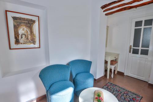 a living room with blue chairs and a table at Chems Bleu in Essaouira